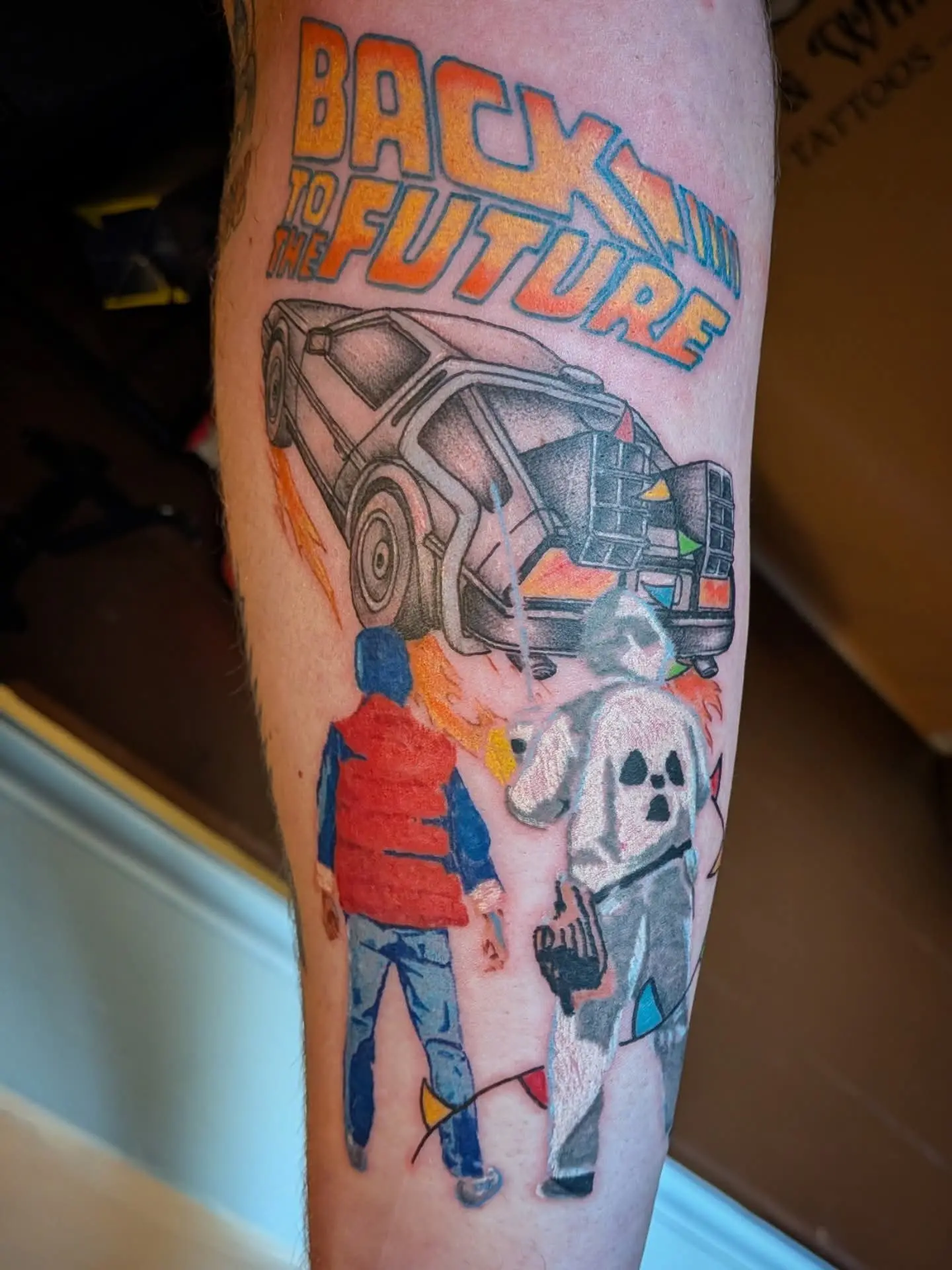 Colour Back to the Future tattoo with the DeLorean, Marty and Doc
