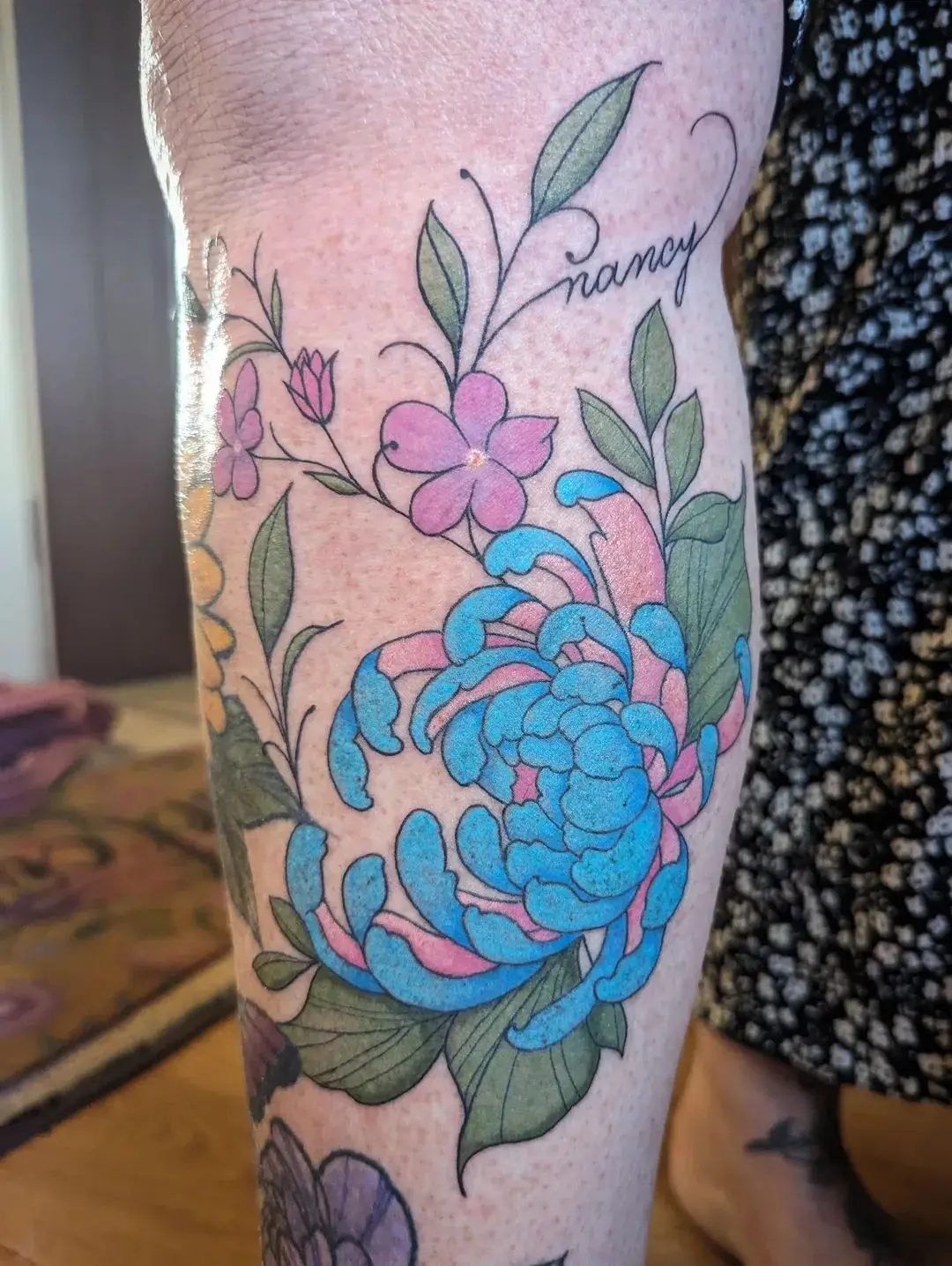 Colour tattoo of a blue chrysanthemum with pink blossoms and script